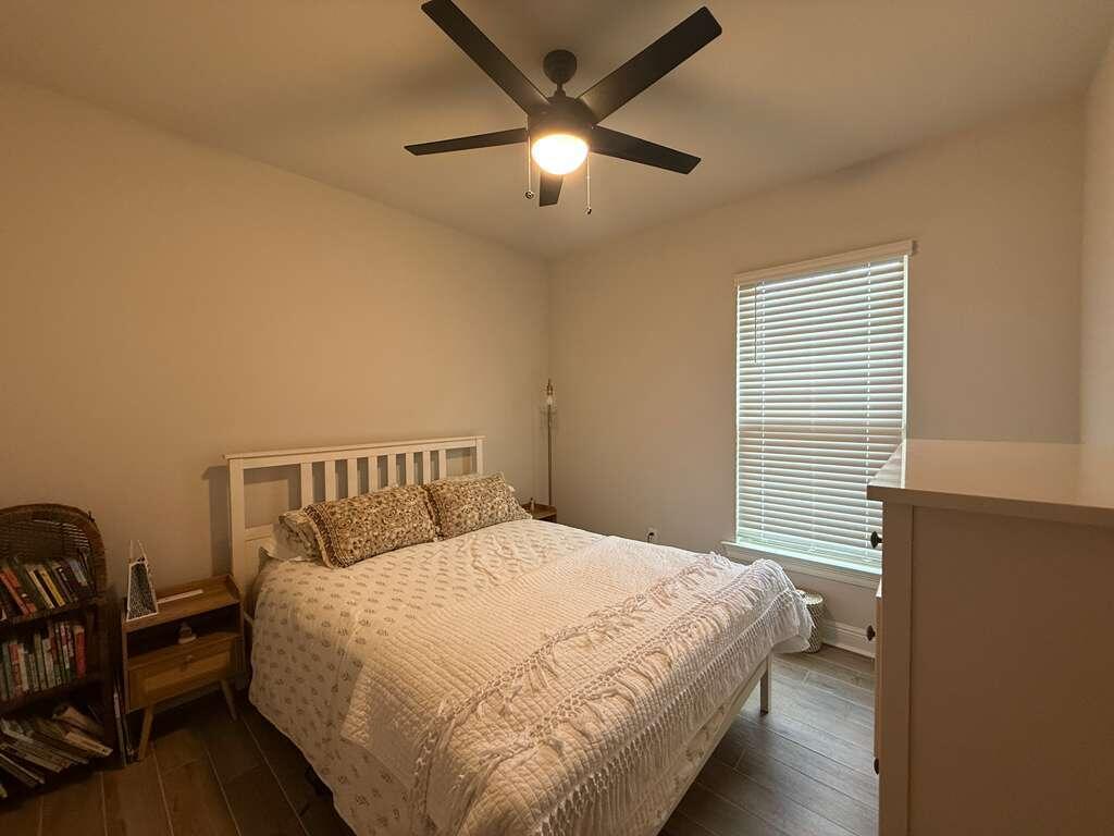 115 Apollo Avenue Freeport, FL 32439 - Photo 19 of 26 a large bed sitting in a bedroom next to a window and a chandelier