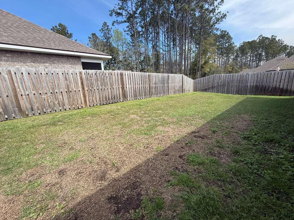 115 Apollo Avenue Freeport, FL 32439 - Photo 22 of 26 a view of a backyard with wooden fence