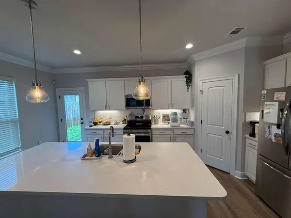 a kitchen with a table chairs and refrigerator