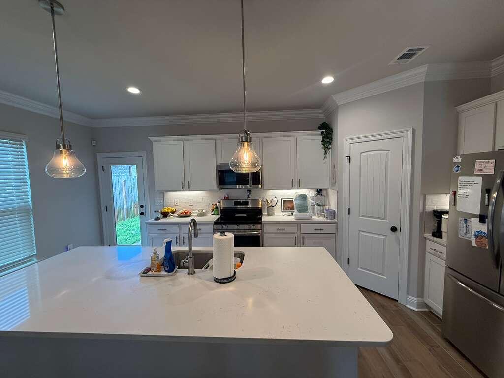 115 Apollo Avenue Freeport, FL 32439 - Photo 5 of 26 a kitchen with a table chairs and refrigerator