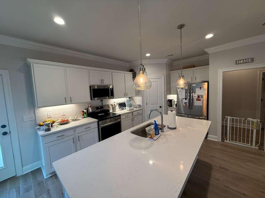 115 Apollo Avenue Freeport, FL 32439 - Photo 6 of 26 a kitchen with sink a refrigerator and wooden cabinets