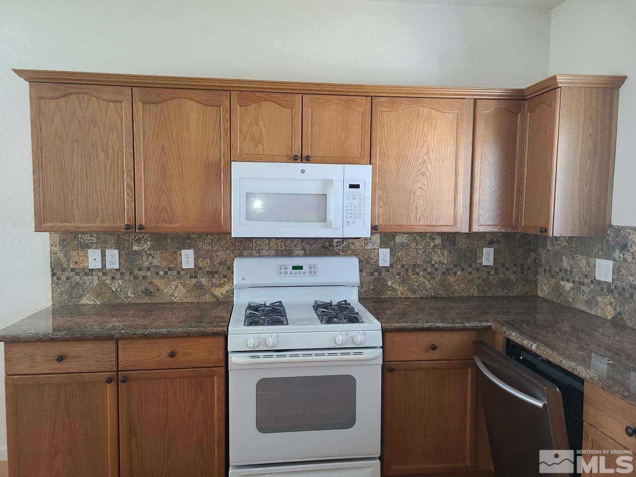 10350 Rosemount Drive Reno, NV 89521 - Photo 3 of 13 a kitchen with granite countertop wood cabinets and white appliances