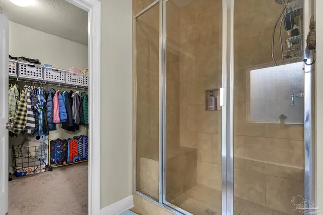 a view of walk in closet with clothes