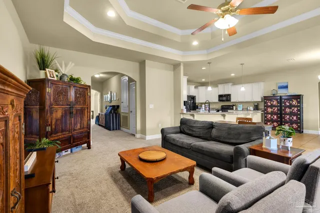 a living room with furniture and a view of kitchen