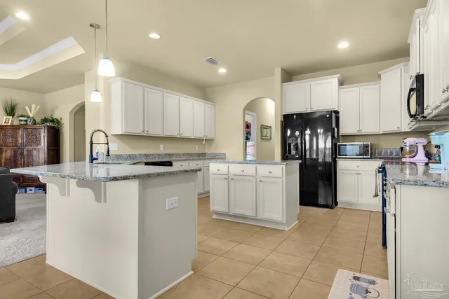 a kitchen with stainless steel appliances granite countertop a refrigerator sink and cabinets