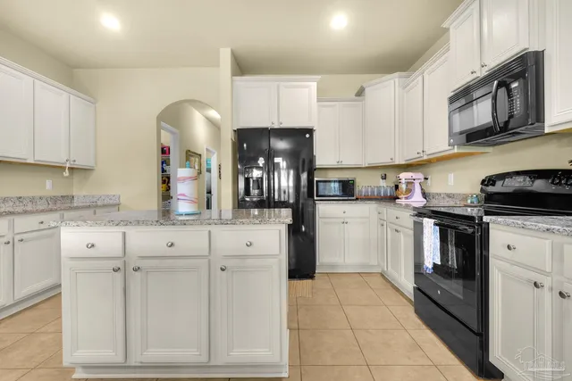 a kitchen with white cabinets and appliances