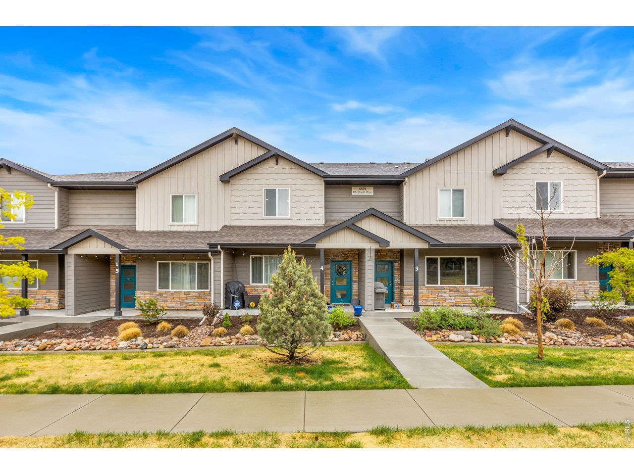 6609 4th St Road, Unit 4 Greeley, CO 80634 - Photo 1 of 41 a front view of a house with a yard table and chairs