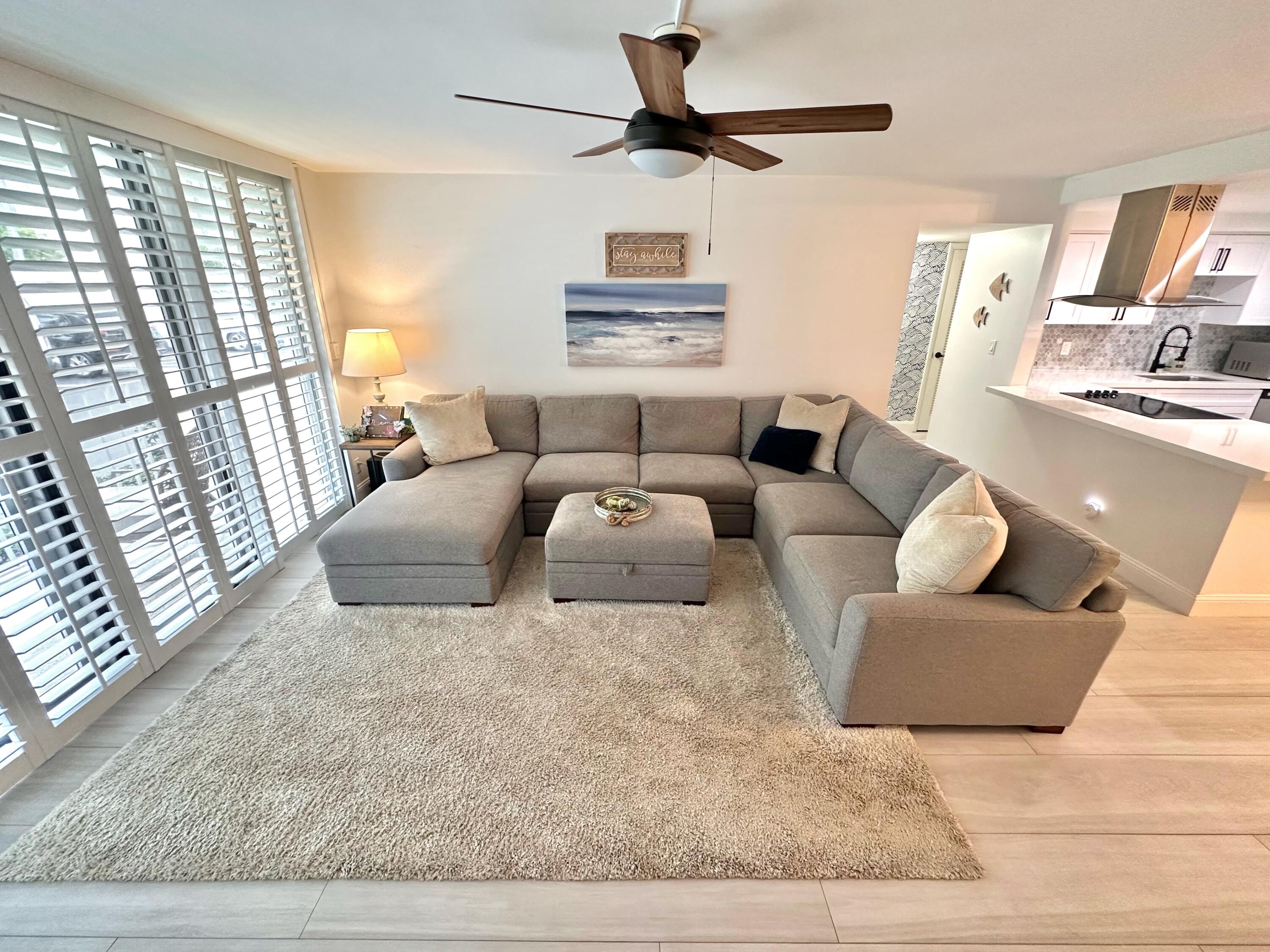 630 Ocean Drive, Unit 105 Juno Beach, FL 33408 - Photo 11 of 37 a living room with furniture and a large window