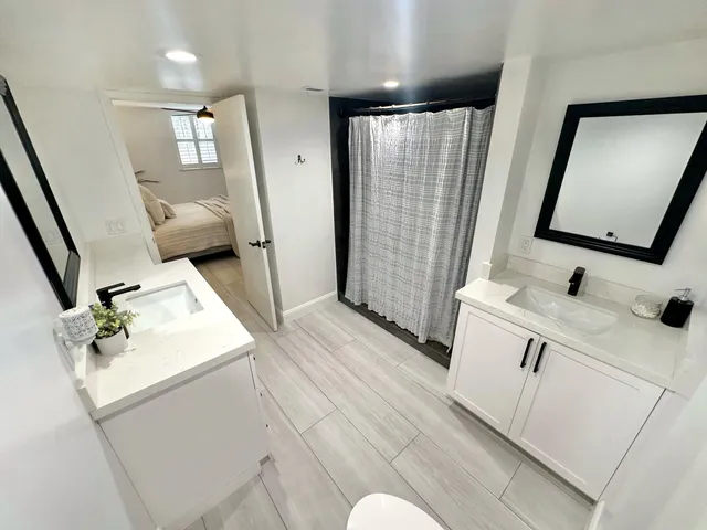 a bathroom with a sink vanity granite tub and shower