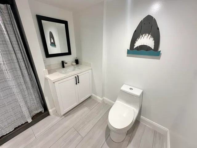 a bathroom with a toilet a sink and mirror