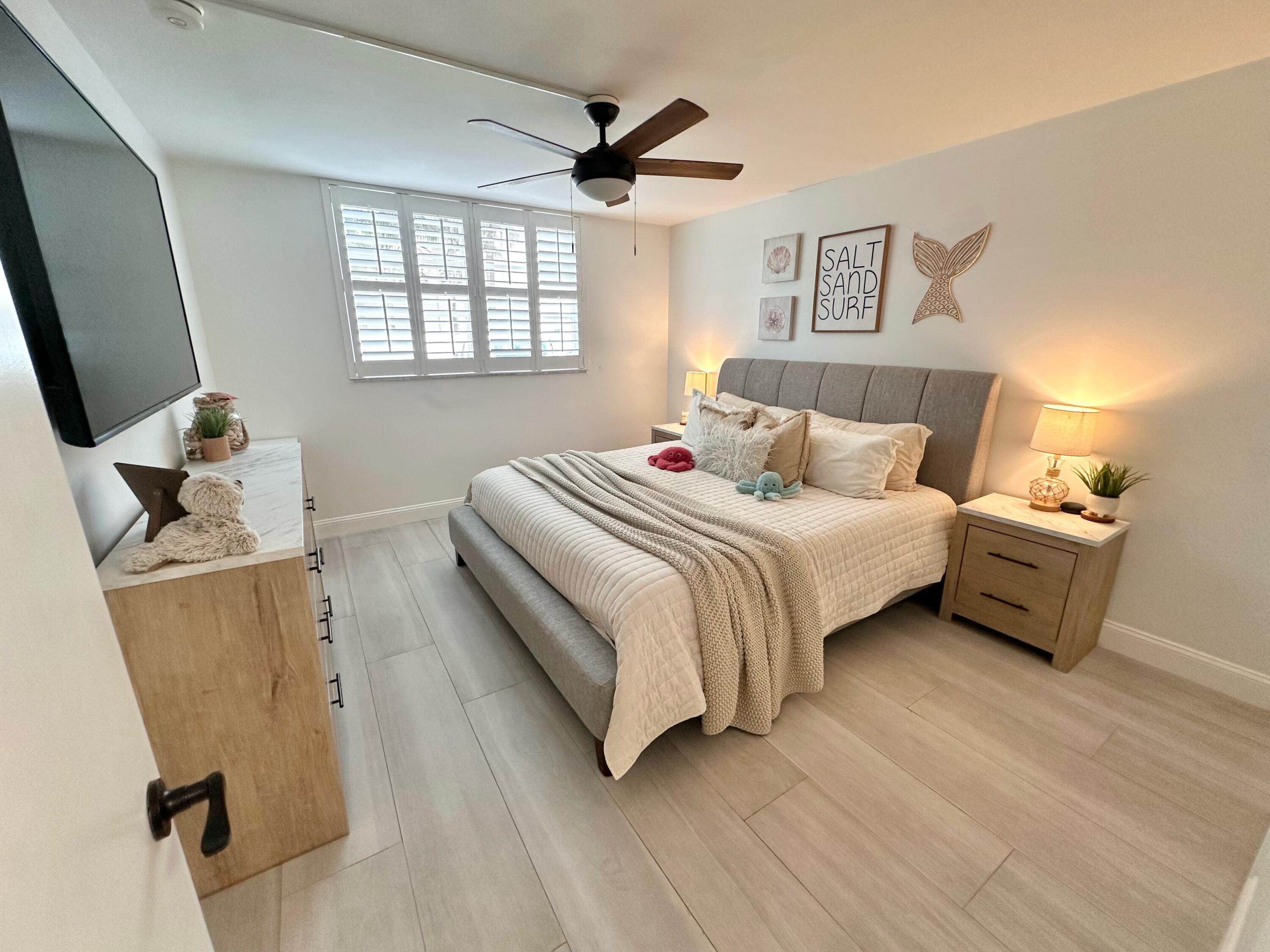 630 Ocean Drive, Unit 105 Juno Beach, FL 33408 - Photo 20 of 37 a bedroom with a bed and a flat screen tv