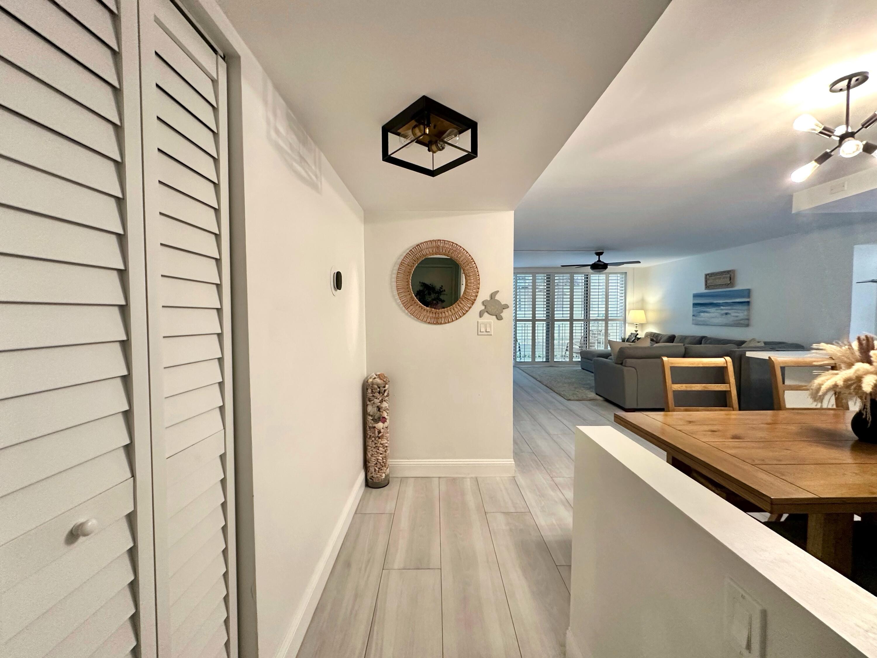 630 Ocean Drive, Unit 105 Juno Beach, FL 33408 - Photo 2 of 37 a view of kitchen and living room with wooden floor