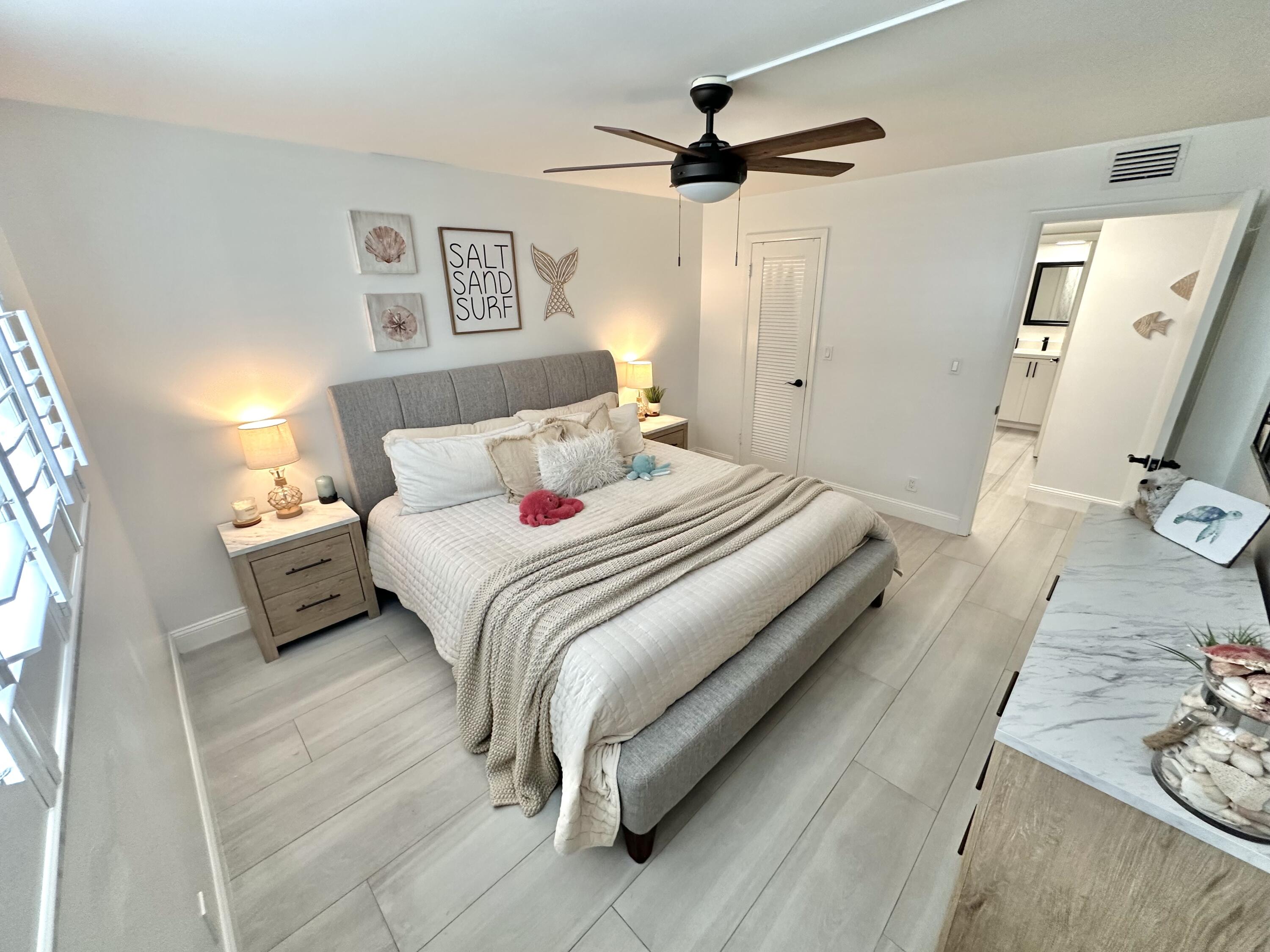 630 Ocean Drive, Unit 105 Juno Beach, FL 33408 - Photo 21 of 37 a bedroom with a bed and a flat screen tv