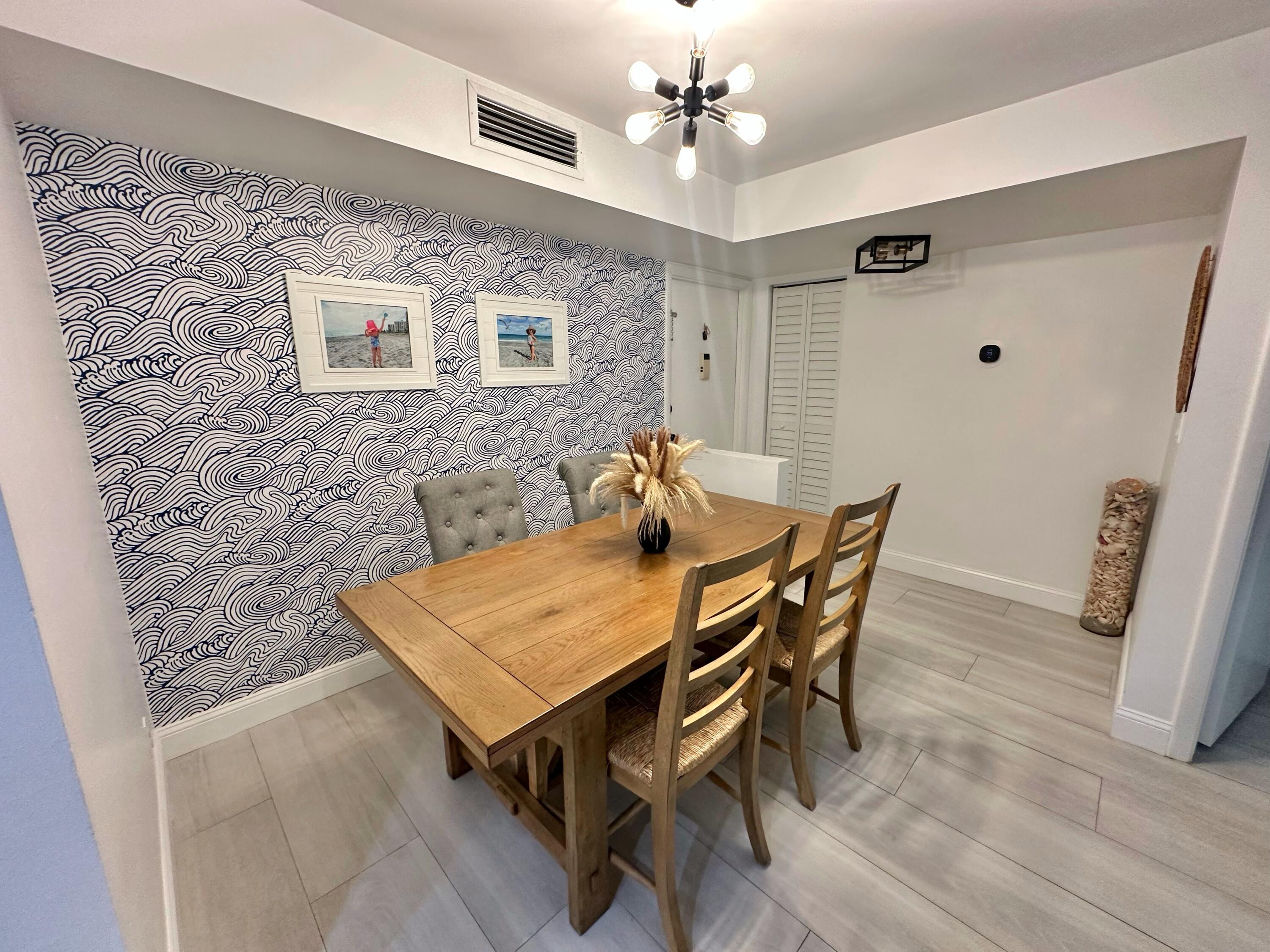 630 Ocean Drive, Unit 105 Juno Beach, FL 33408 - Photo 3 of 37 a view of a dining room with furniture and wooden floor