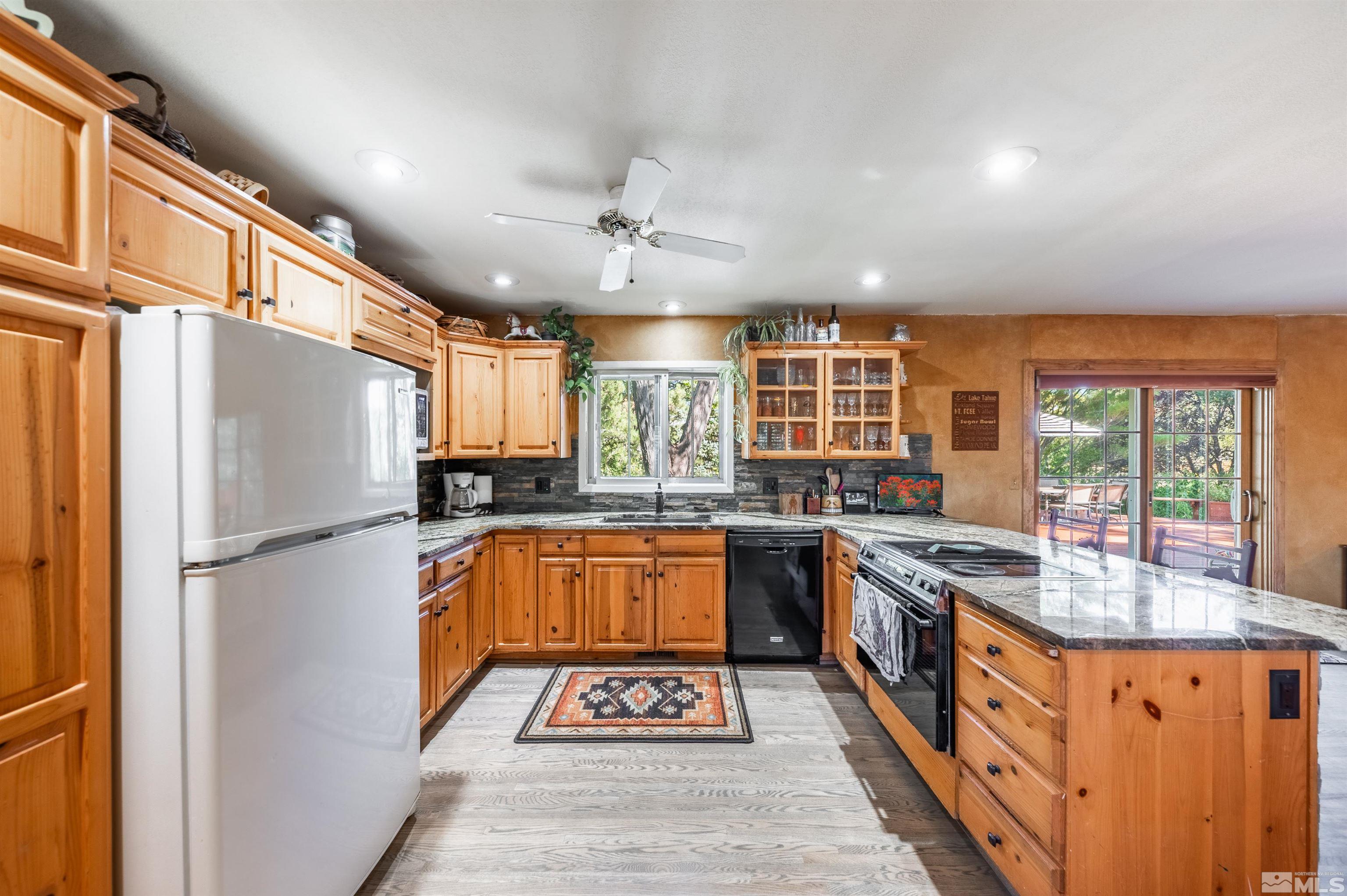 9820 Dixon Lane Reno, NV 89511 - Photo 6 of 40 a kitchen with stainless steel appliances granite countertop a refrigerator a sink dishwasher a stove with white cabinets and wooden floor