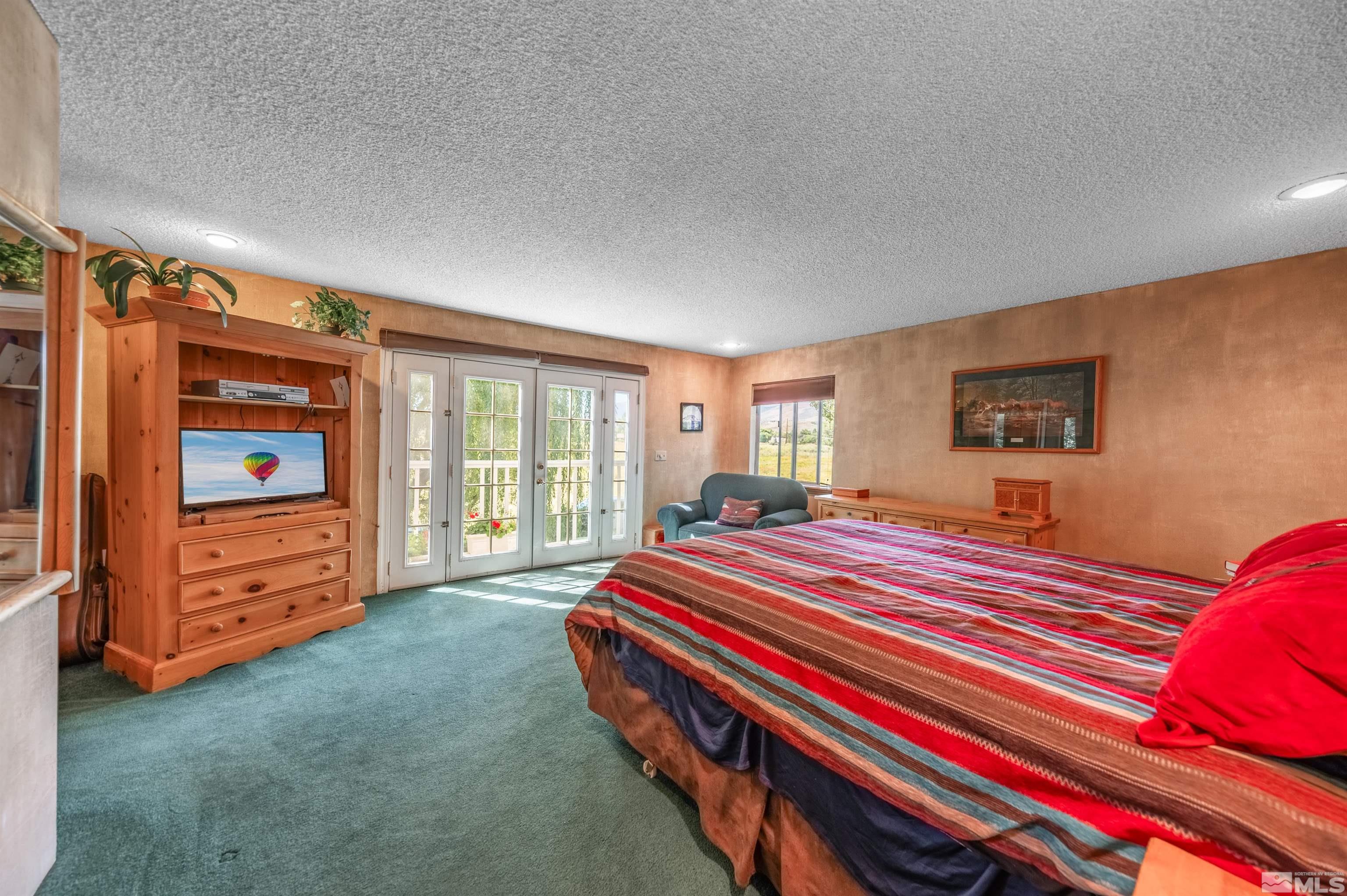 9820 Dixon Lane Reno, NV 89511 - Photo 10 of 40 a spacious bedroom with a bed and a dresser next to a window
