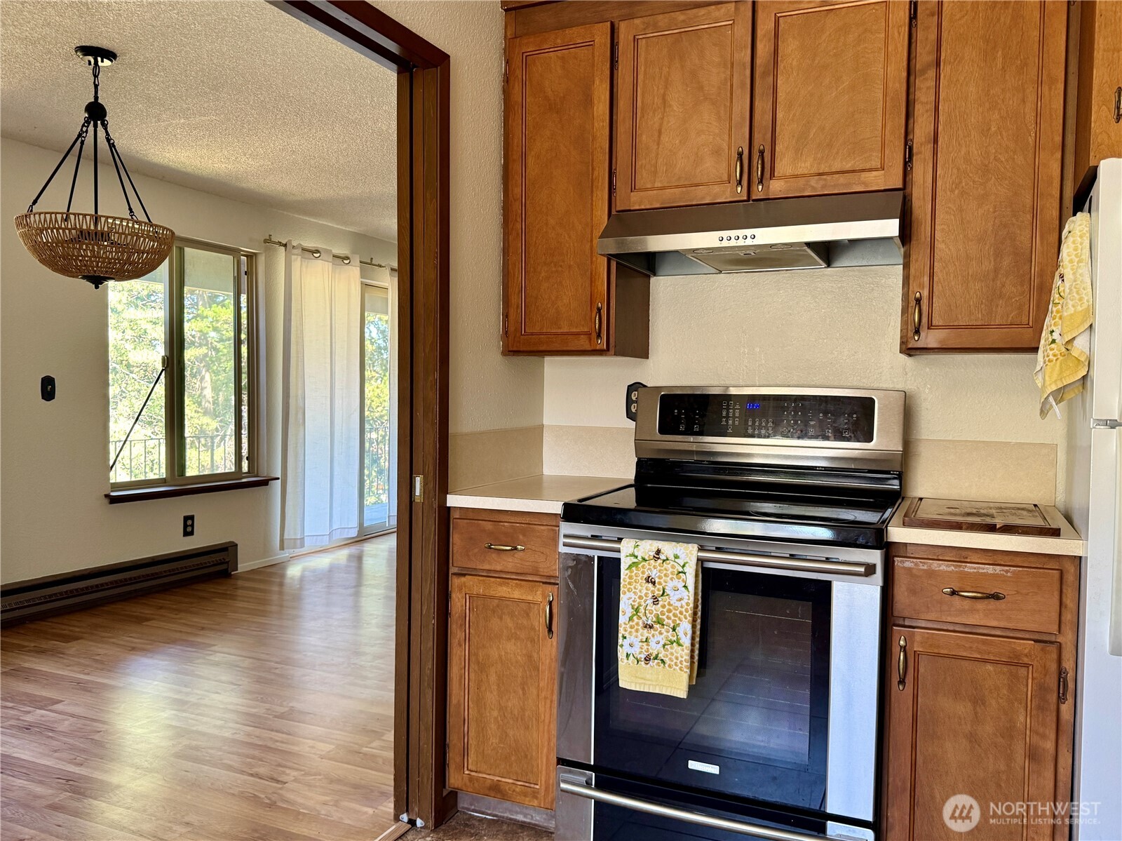 2520 Cascade Place West, Unit 2520 University Place, WA 98466 - Photo 14 of 35 a kitchen with stainless steel appliances a stove a microwave and a wooden floor