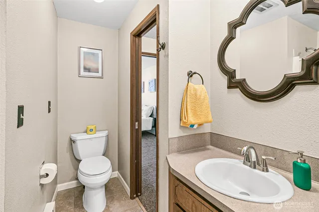 a bathroom with a toilet sink and mirror