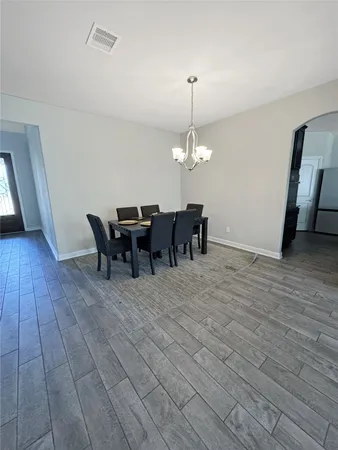 a view of a dining room with furniture and chandelier