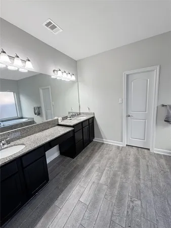 a bathroom with a double vanity sink and a mirror