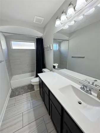 a bathroom with a sink a toilet a mirror and shower