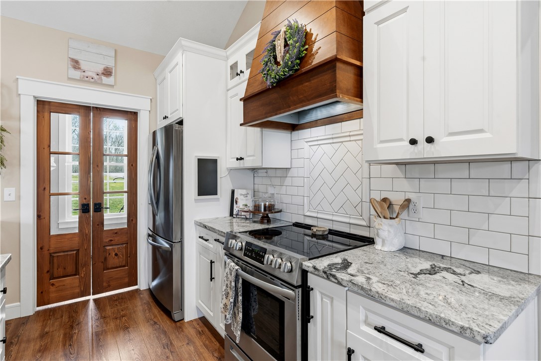 1158 Pyle Road Clarksville, OH 45113 - Photo 23 of 76 This bright kitchen features modern appliances, ample counter space, and a charming wooden pantry door.