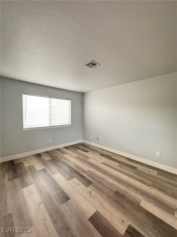 678 Anne Lane, Unit 678 Henderson, NV 89015 - Photo 13 of 14 Spare room with a textured ceiling and light wood-style floors