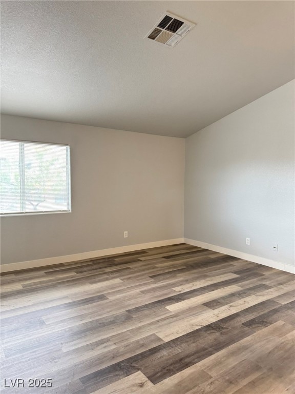 678 Anne Lane, Unit 678 Henderson, NV 89015 - Photo 3 of 14 Unfurnished room featuring wood finished floors and a textured ceiling