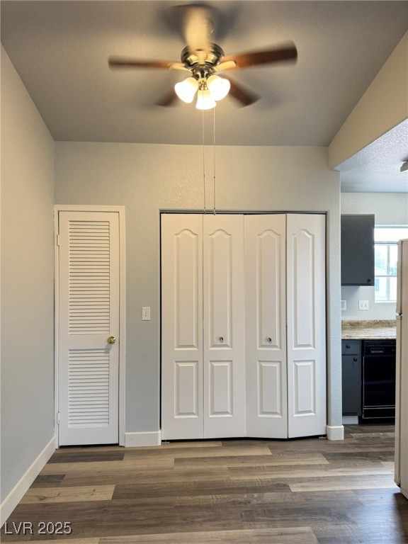 678 Anne Lane, Unit 678 Henderson, NV 89015 - Photo 6 of 14 Unfurnished bedroom with connected bathroom, dark wood finished floors, ceiling fan, and multiple closets