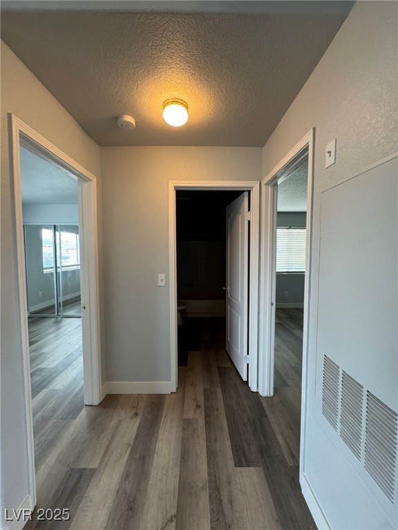 678 Anne Lane, Unit 678 Henderson, NV 89015 - Photo 10 of 14 Corridor with a textured ceiling and dark wood-style flooring