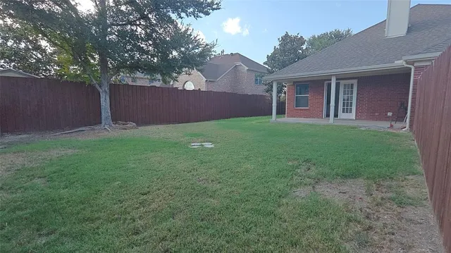 a view of a yard in front of a house with large tree