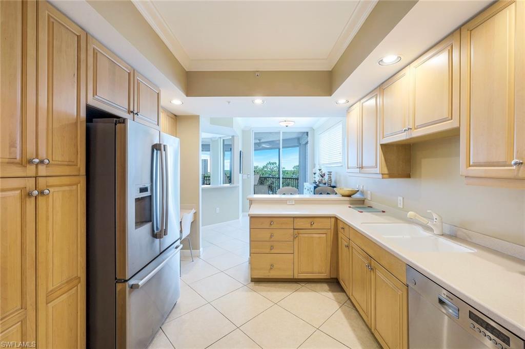 325 Dunes Boulevard, Unit 406 Naples, FL 34110 - Photo 7 of 21 a kitchen with stainless steel appliances granite countertop a refrigerator and a sink