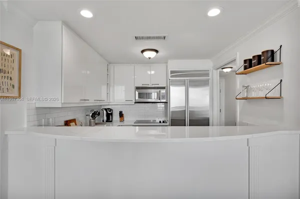 a kitchen with stainless steel appliances granite countertop a refrigerator and a stove top oven