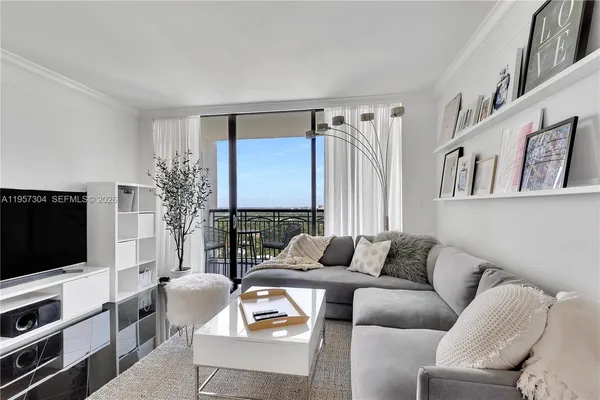 a living room with furniture a flat screen tv and a window