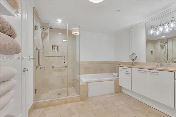 a bathroom with a bathtub shower sink mirror and toilet
