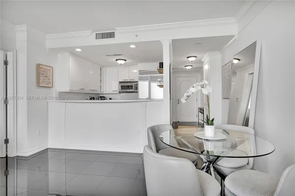 a kitchen with stainless steel appliances kitchen island granite countertop a table and chairs in it