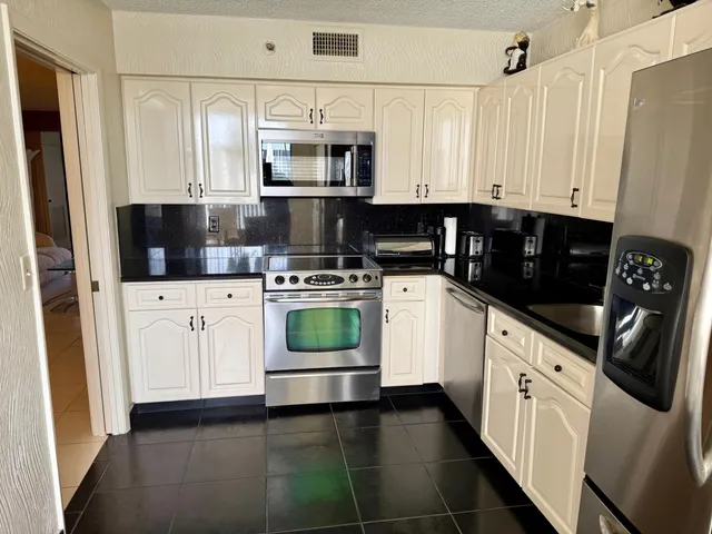 a kitchen with white cabinets and white appliances