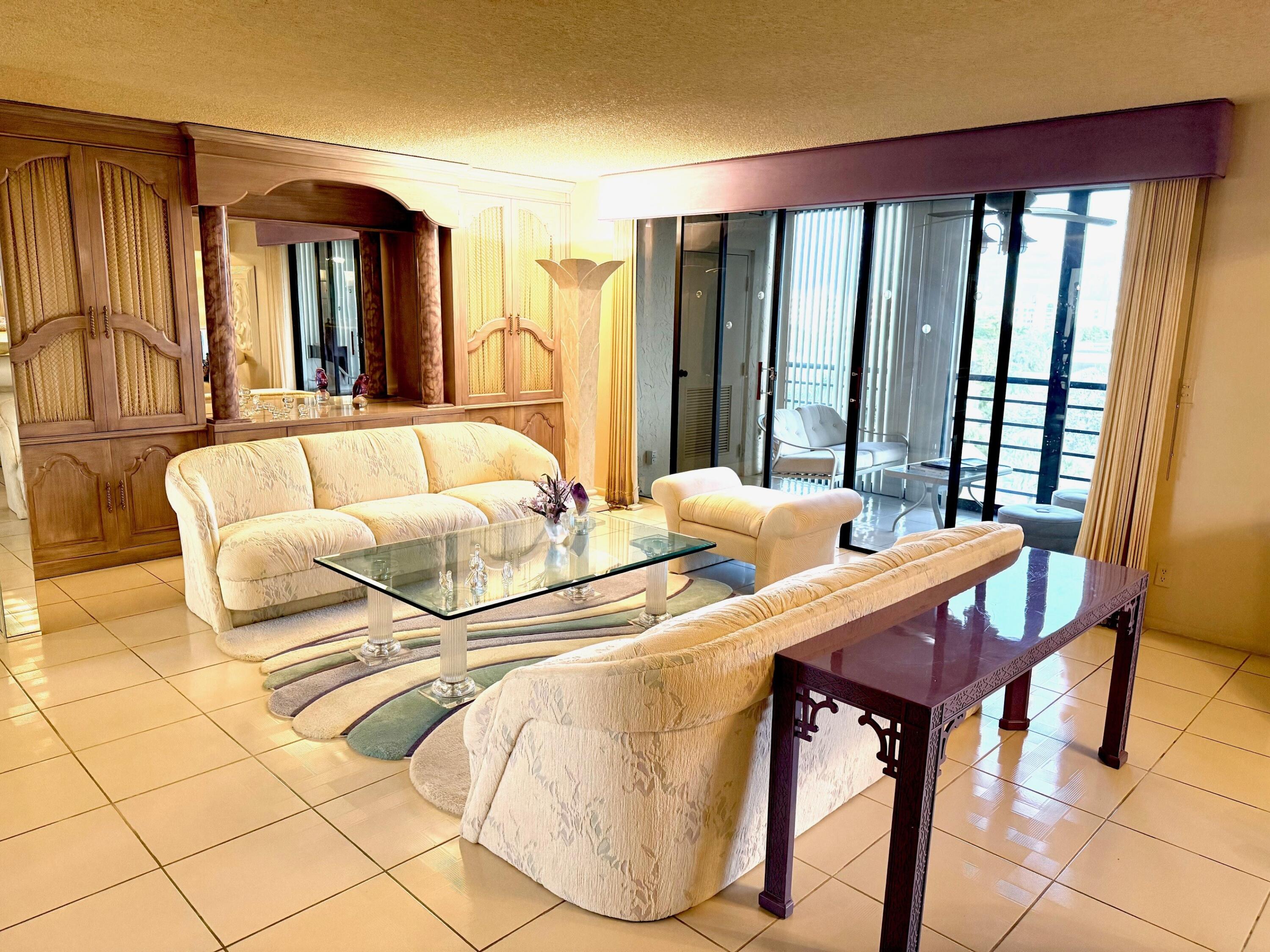 7564 Regency Lake Drive, Unit 702 Boca Raton, FL 33433 - Photo 10 of 40 a living room with furniture and a large window