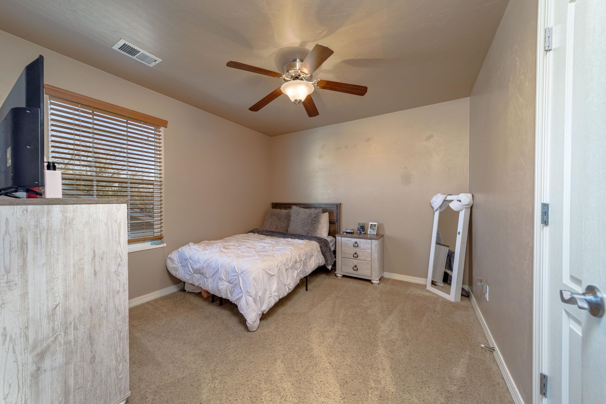 1124 West Addington Lane Fruita, CO 81521 - Photo 17 of 25 a bedroom with a bed and a chandelier