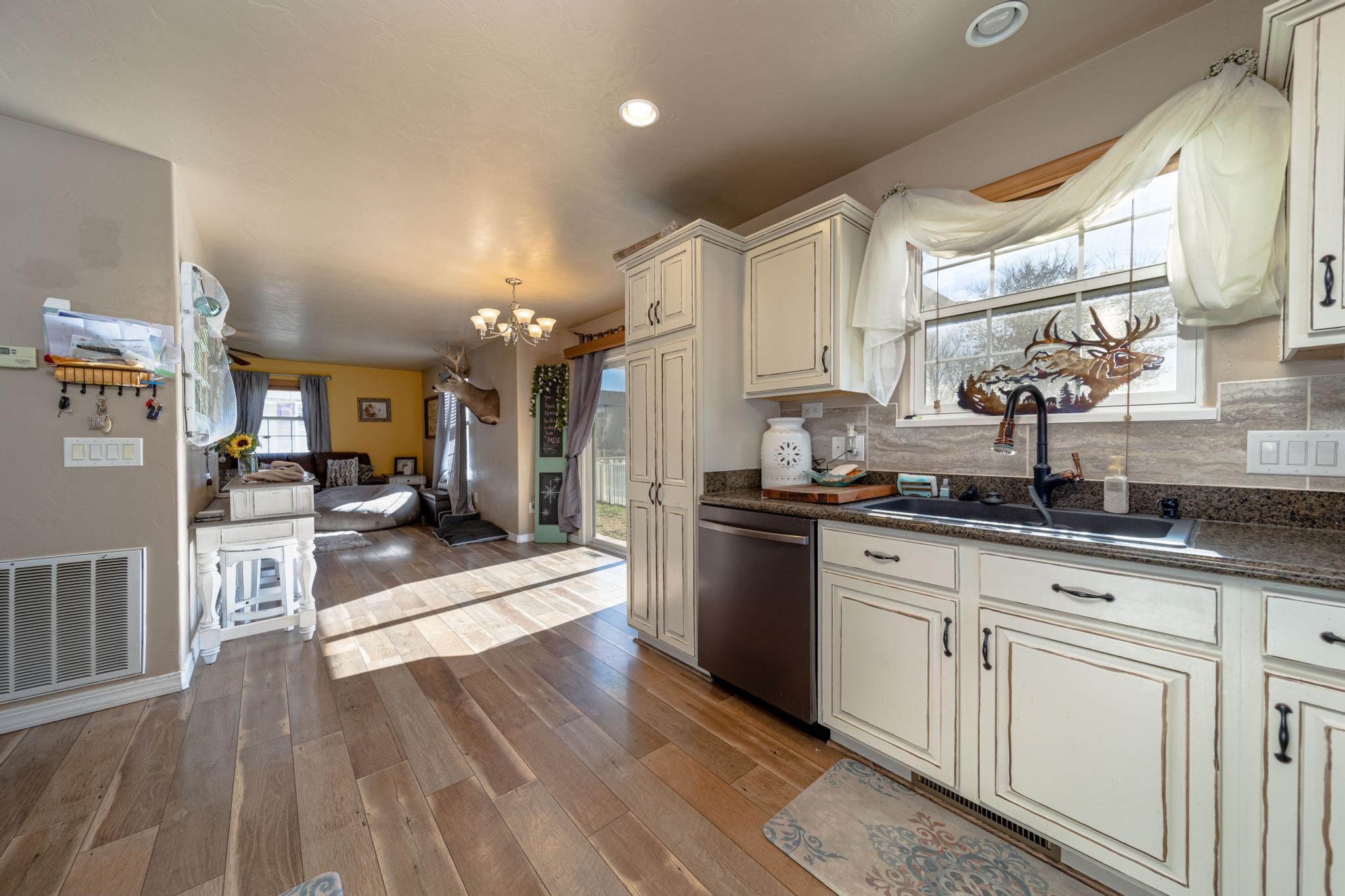 1124 West Addington Lane Fruita, CO 81521 - Photo 4 of 25 a large kitchen with cabinets wooden floor and stainless steel appliances