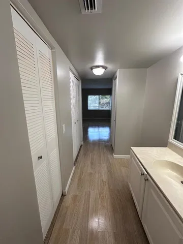 an empty room with wooden floor and windows