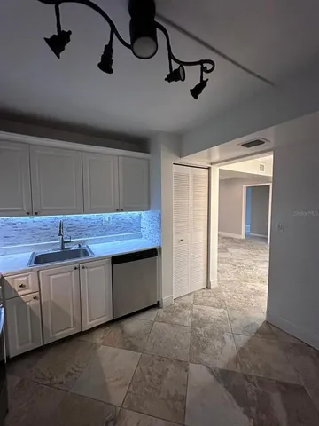 an empty room with wooden floor and chandelier