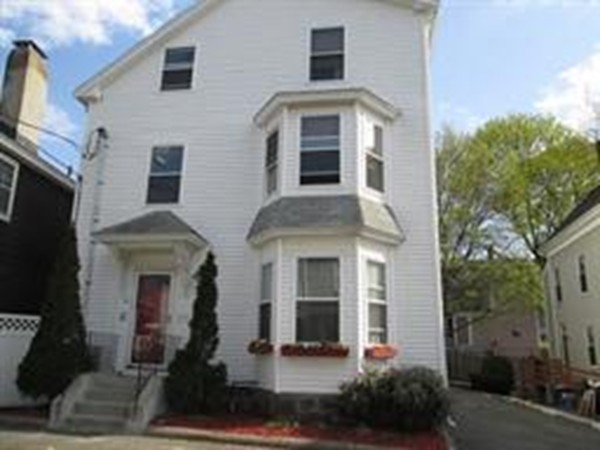 44 Wallis Street, Unit 1 Beverly, MA 01915 - Photo 1 of 3 a front view of a house with a yard