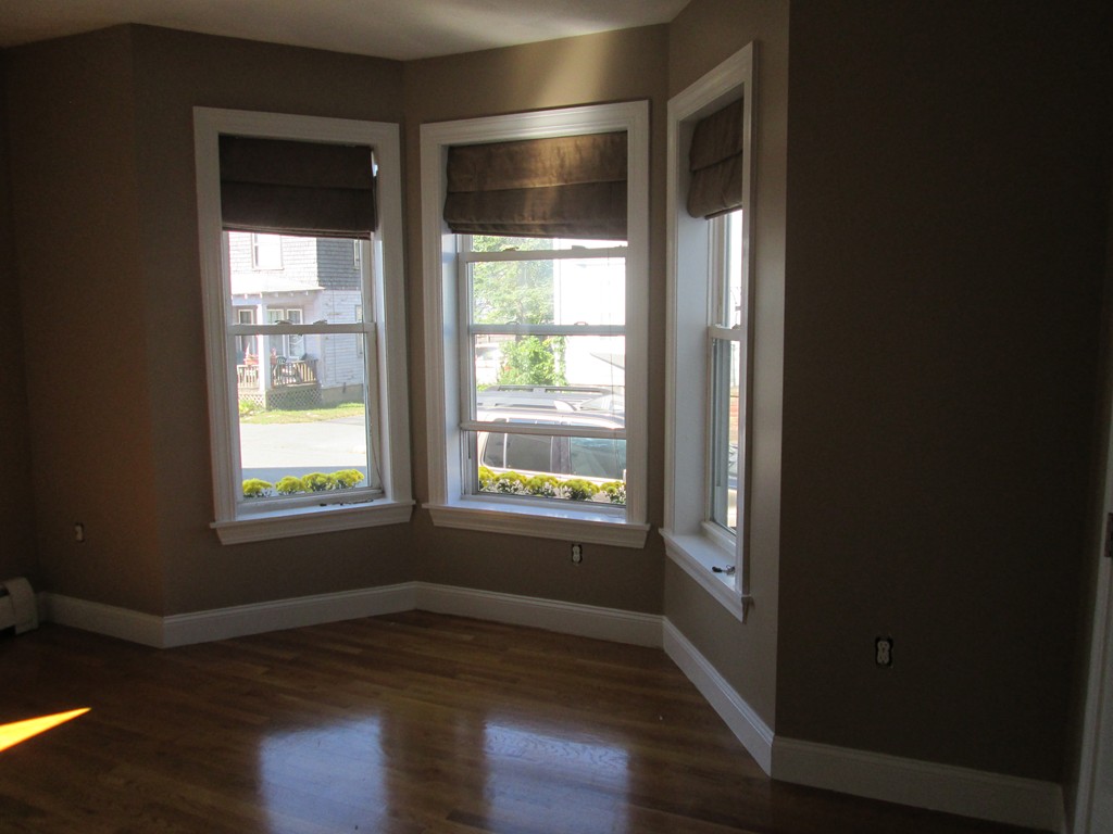 44 Wallis Street, Unit 1 Beverly, MA 01915 - Photo 2 of 3 a view of an empty room with wooden floor and a window