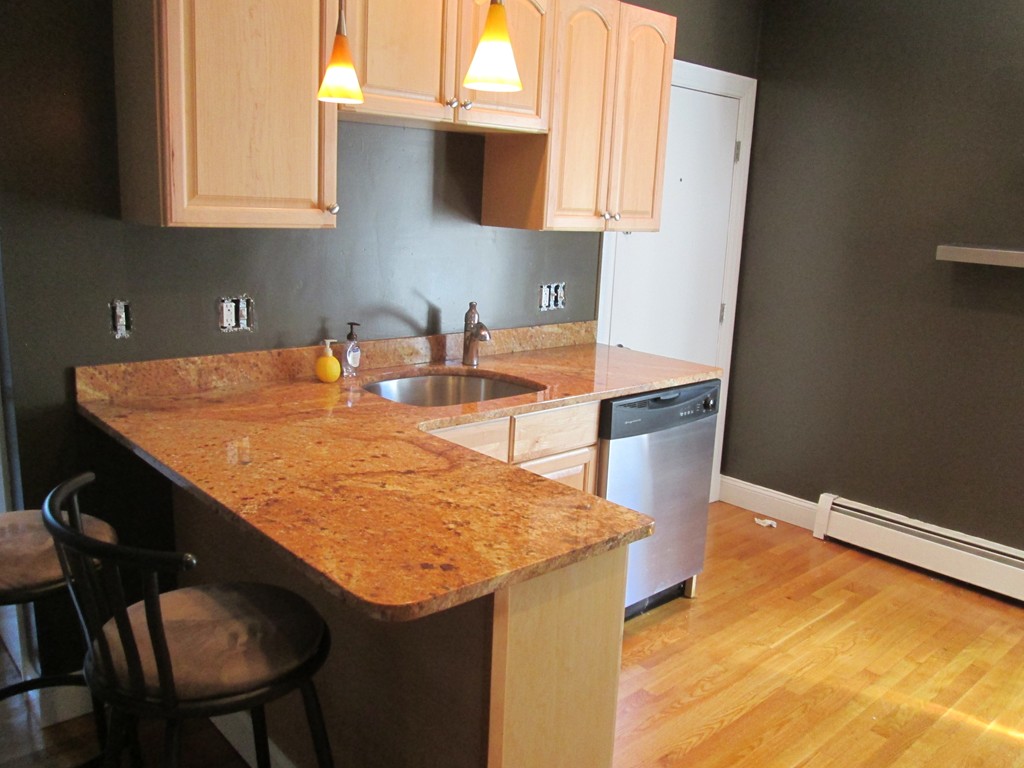 44 Wallis Street, Unit 1 Beverly, MA 01915 - Photo 3 of 3 a kitchen with stainless steel appliances granite countertop a sink a stove and a microwave