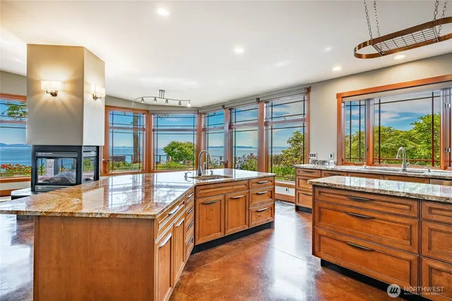 a large kitchen with kitchen island granite countertop a large window and a counter space