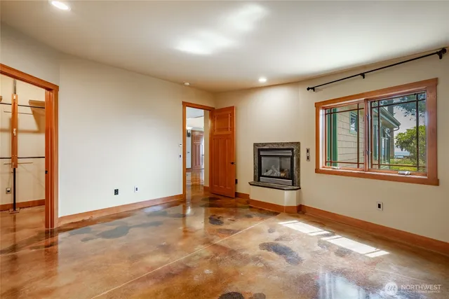 an empty room with windows and fireplace