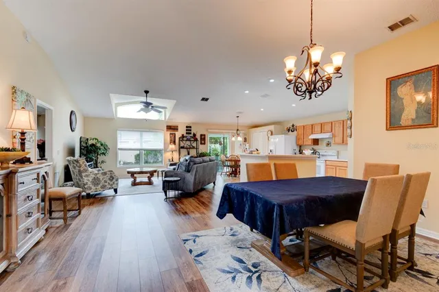 a view of a livingroom with furniture a chandelier and wooden floor