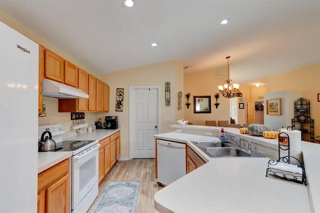 a large white kitchen with lots of counter space and sink