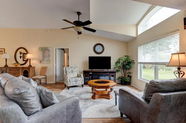 a living room with furniture a window and a flat screen tv